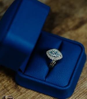Cushion halo engagement ring in a blue box